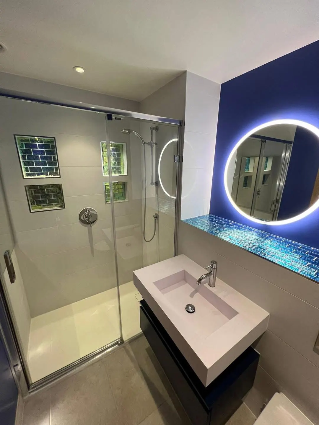 Bathroom with illuminated round mirror