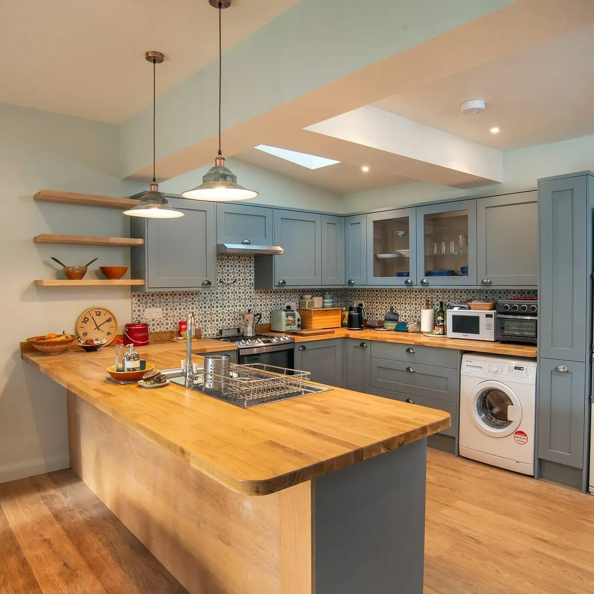 Shaker kitchen with enamel pendants over an oak worktop